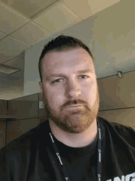 a man with a beard wears a lanyard that says boeing on it