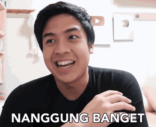 a young man is smiling and says nanggung banget on the bottom