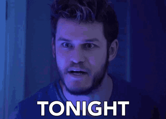 a man with a beard is screaming with the word tonight behind him