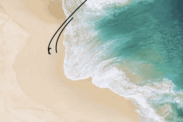 an aerial view of a sandy beach with waves crashing on it