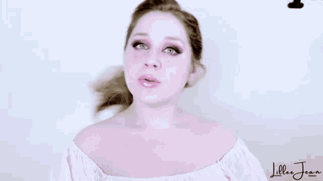 a woman in a pink off the shoulder top is making a face .