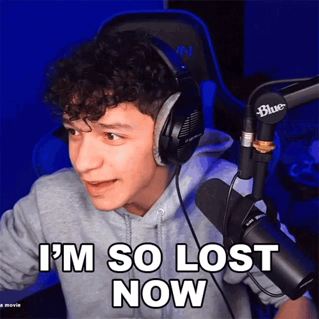 a man wearing headphones next to a blue microphone says i 'm so lost now