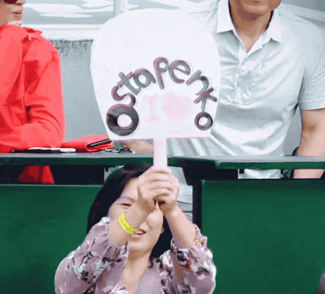 a woman is holding a sign that says stopenxo