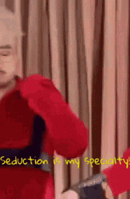 a man in a red sweater is dancing with the words seduction is my specialty written below him