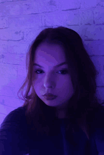 a woman taking a selfie in front of a purple wall