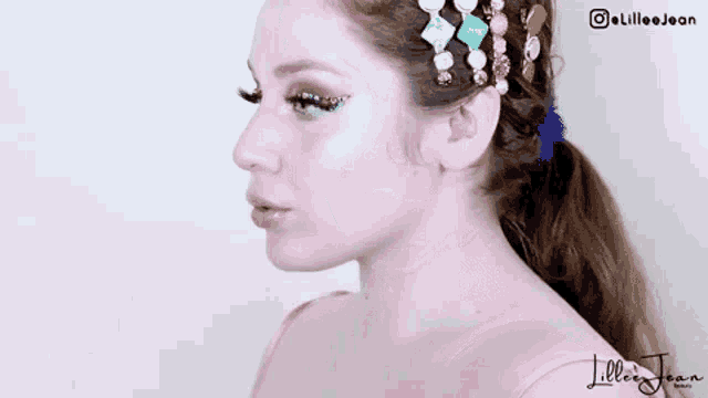 a close up of a woman 's face with makeup and hair clips in her hair .
