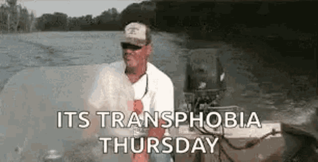 a man is sitting in a boat in the water with the words `` it 's transphobia thursday '' .