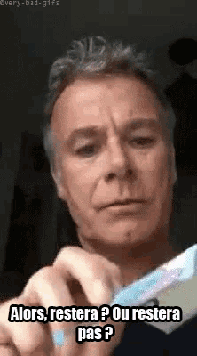 a man is holding a toothbrush and making a funny face .