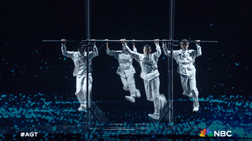 a group of people are dancing on a stage with a nbc logo in the background