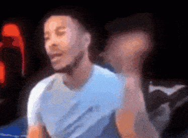 a blurry picture of a man in a light blue shirt