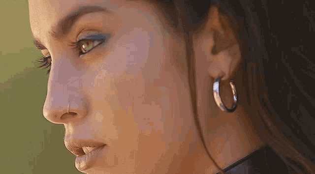 a close up of a woman 's face wearing hoop earrings .