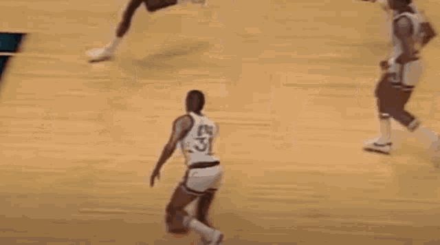 a basketball player is kneeling down on the court while playing a game of basketball .