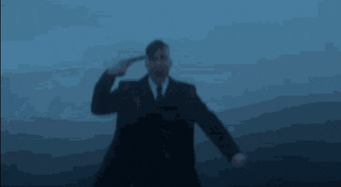 a man in a suit and tie is pointing his finger at his head ..