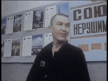 a man stands in front of a sign that says ' soko hepyshim '