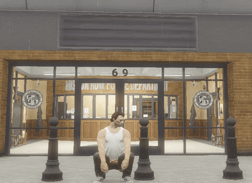a man squats in front of a building with the number 69