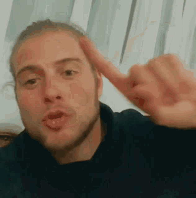 a man is making a funny face and pointing his finger