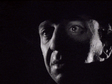 a black and white photo of a man 's face with a hat on