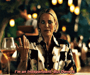 a woman sitting at a table with a glass of wine says " i 'm an independent but dave is "