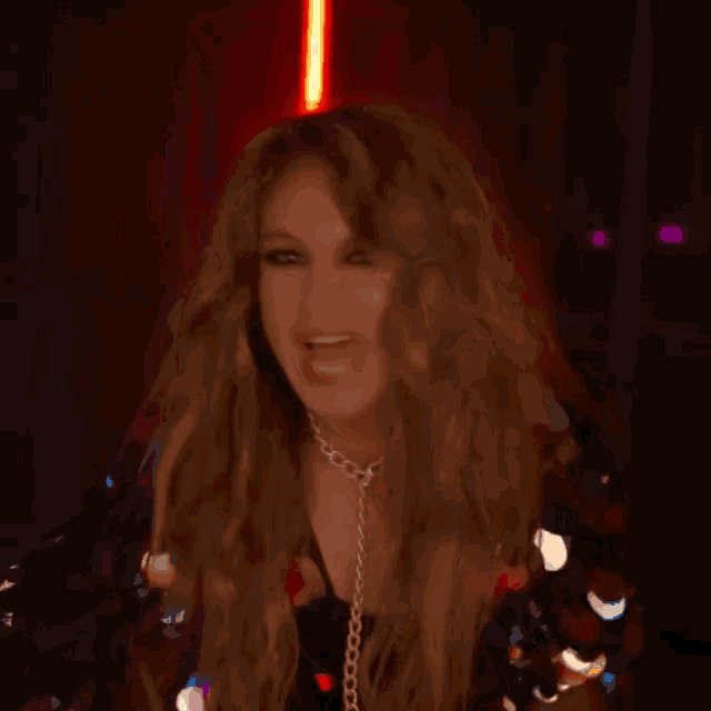 a woman with long hair is making a funny face while wearing a necklace .