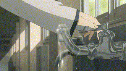 a person is washing their hands at a faucet in a hallway .
