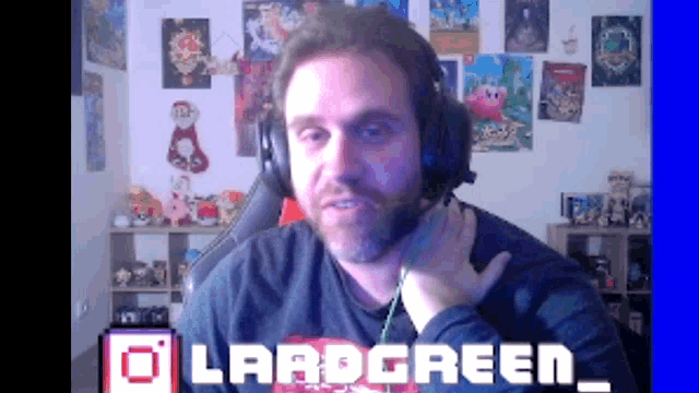 a man wearing headphones is sitting in front of a screen that says lradgreen_