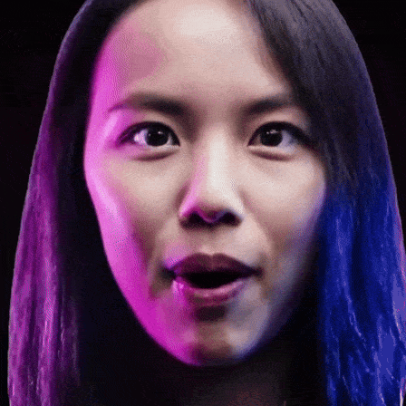 a close up of a woman 's face with purple and blue lights