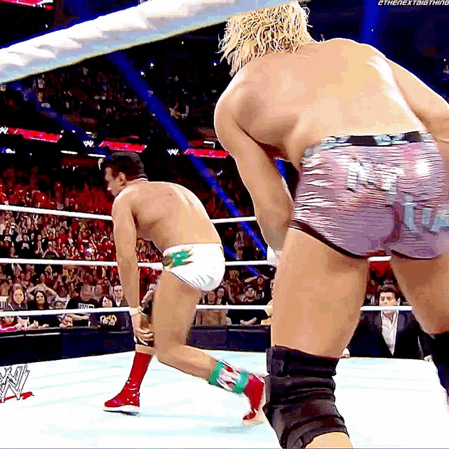 two wrestlers in a wrestling ring with the word enext on the bottom right
