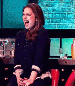 a woman is sitting in a chair with her mouth open