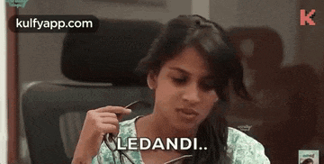 a woman is sitting in a chair holding a pair of glasses and says lendani .