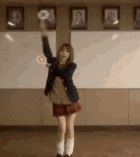 a girl in a school uniform throws a donut in the air