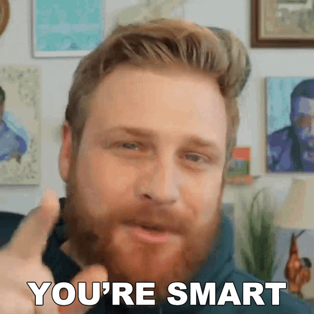 a man with a beard giving a thumbs up with the words you 're smart behind him