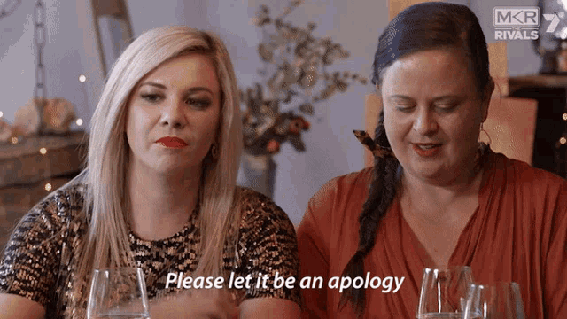 two women are sitting at a table and one of them is asking for an apology