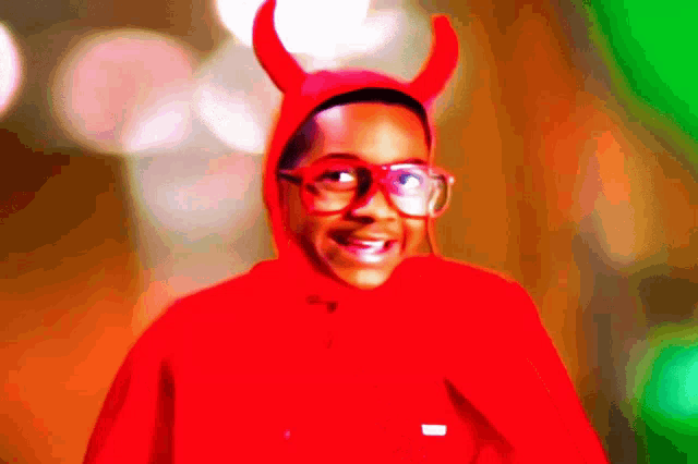 a young boy wearing a red devil costume and glasses