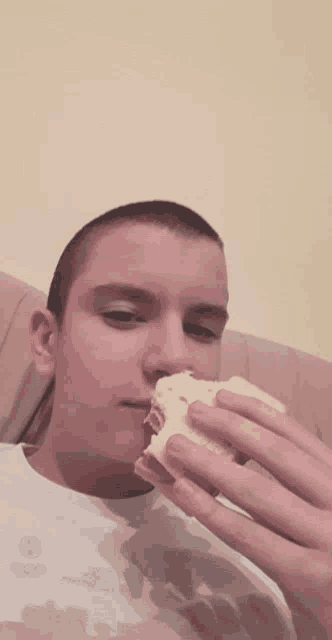 a young man is eating a piece of bread