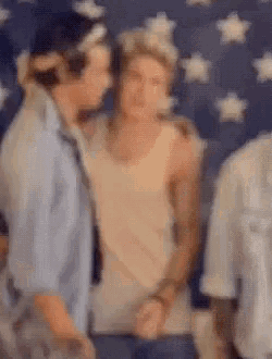 a blurry picture of two men standing next to each other in front of a flag .