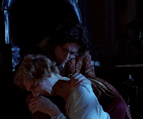 a man kissing a woman 's hand in the dark