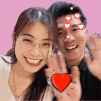 a man and a woman are posing for a picture and the woman has a red heart on her hand