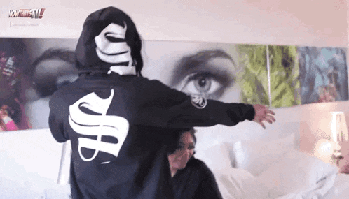 a person wearing a black hoodie with the letter s on the back