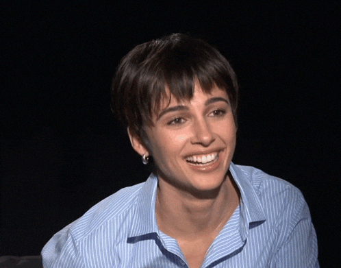 a woman wearing a blue and white striped shirt looks surprised