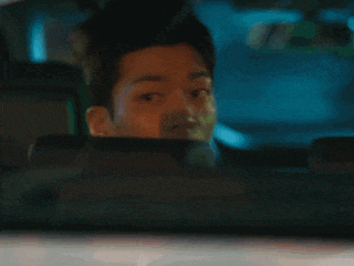 a close up of a man 's face in the rear view mirror of a car .