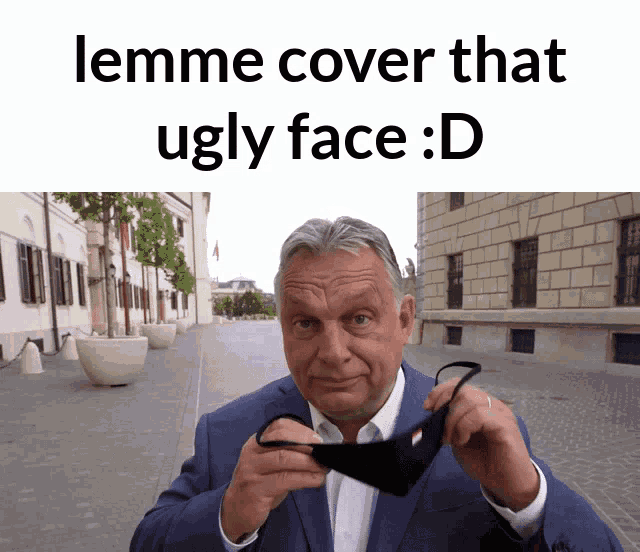 a man in a suit is wearing a mask with the caption " lemme cover that ugly face d "