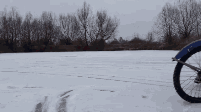 a person riding a motorcycle in the snow with the letter t on their shirt