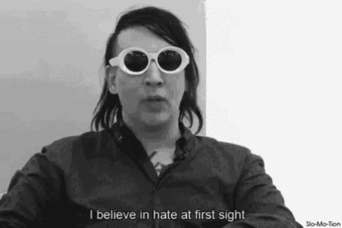 a black and white photo of a man wearing sunglasses and saying i believe in hate at first sight