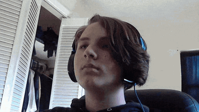 a young man wearing headphones and a black hoodie