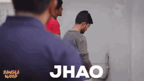a group of men are standing in front of a white wall with the word jhao written on it .