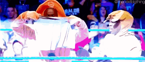 a cartoon of a man holding a piece of paper in a wrestling ring with the nextbigthing written in the corner