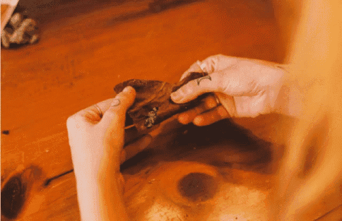 a person with a tattoo on their finger is holding something in their hands