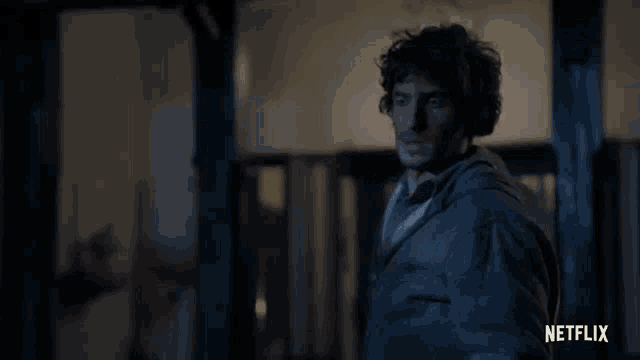 a man is standing in a dark room with a netflix logo in the background