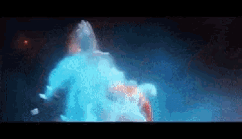 a person is standing in a dark room with a blue light coming out of their head .