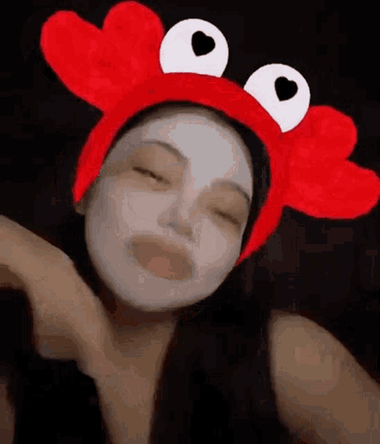 a woman wearing a crab headband with hearts on her eyes .